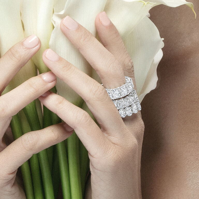 Hands holding flowers while wearing diamond bands